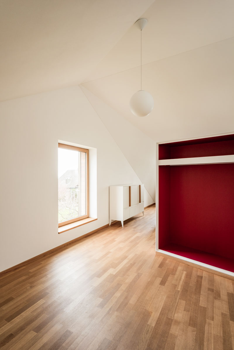 entree-mit-roter-raumtrennender-garderobe-grossem-seitlichem-fenster-und-durchgang-zum-buero-hauptraum