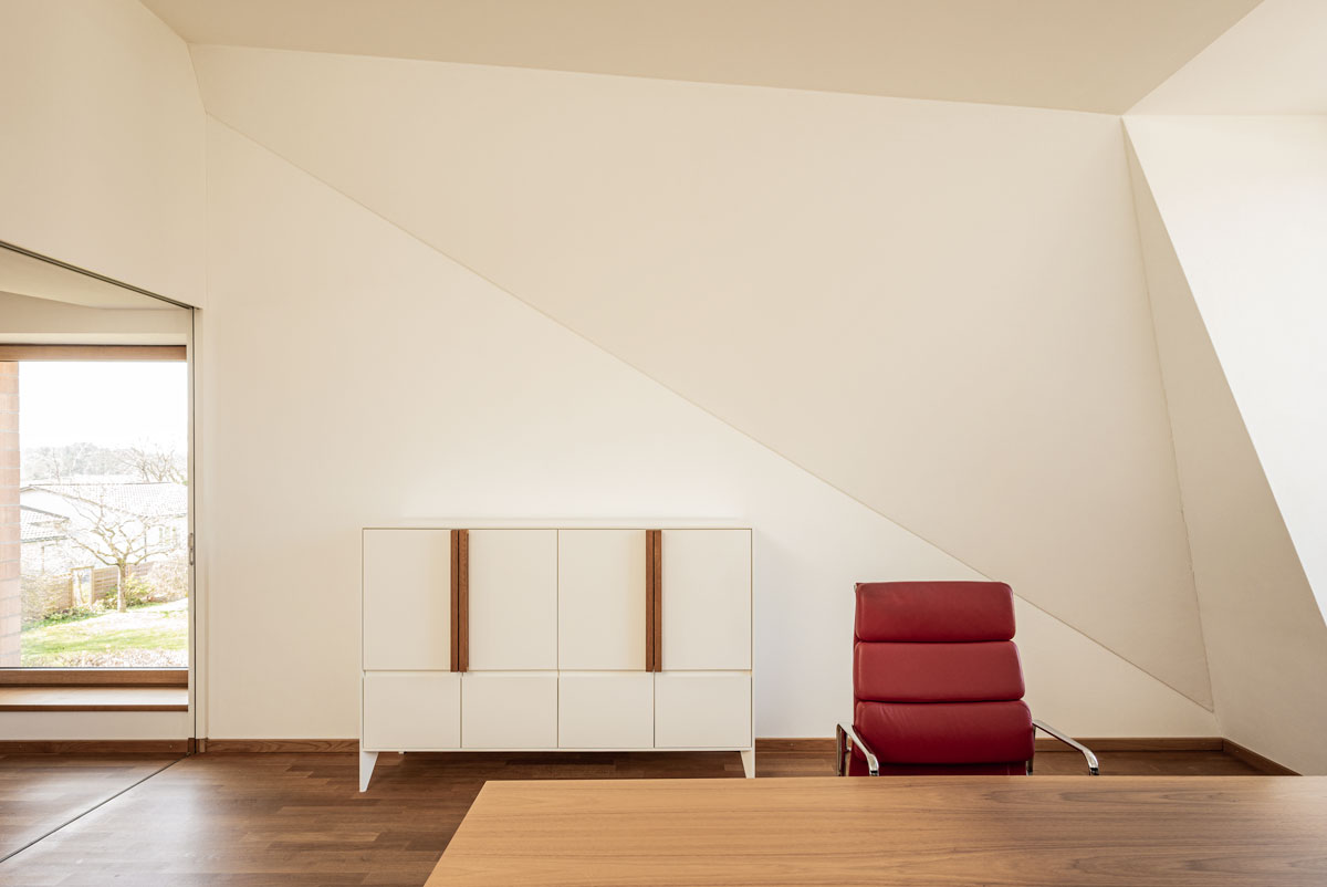sitzungs-zimmer-mit-dachschraege-und-arbeitsplatz-des-chefs-sowie-eigens-entworfenem-archiv-moebel