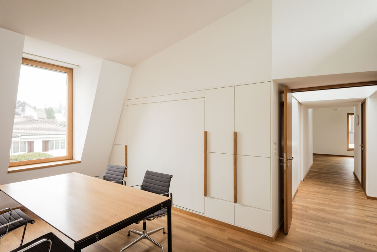 sitzungs-zimmer-mit-besprechungstisch-und-eames-aluminium-chairs-und-durchgang-zum-entree