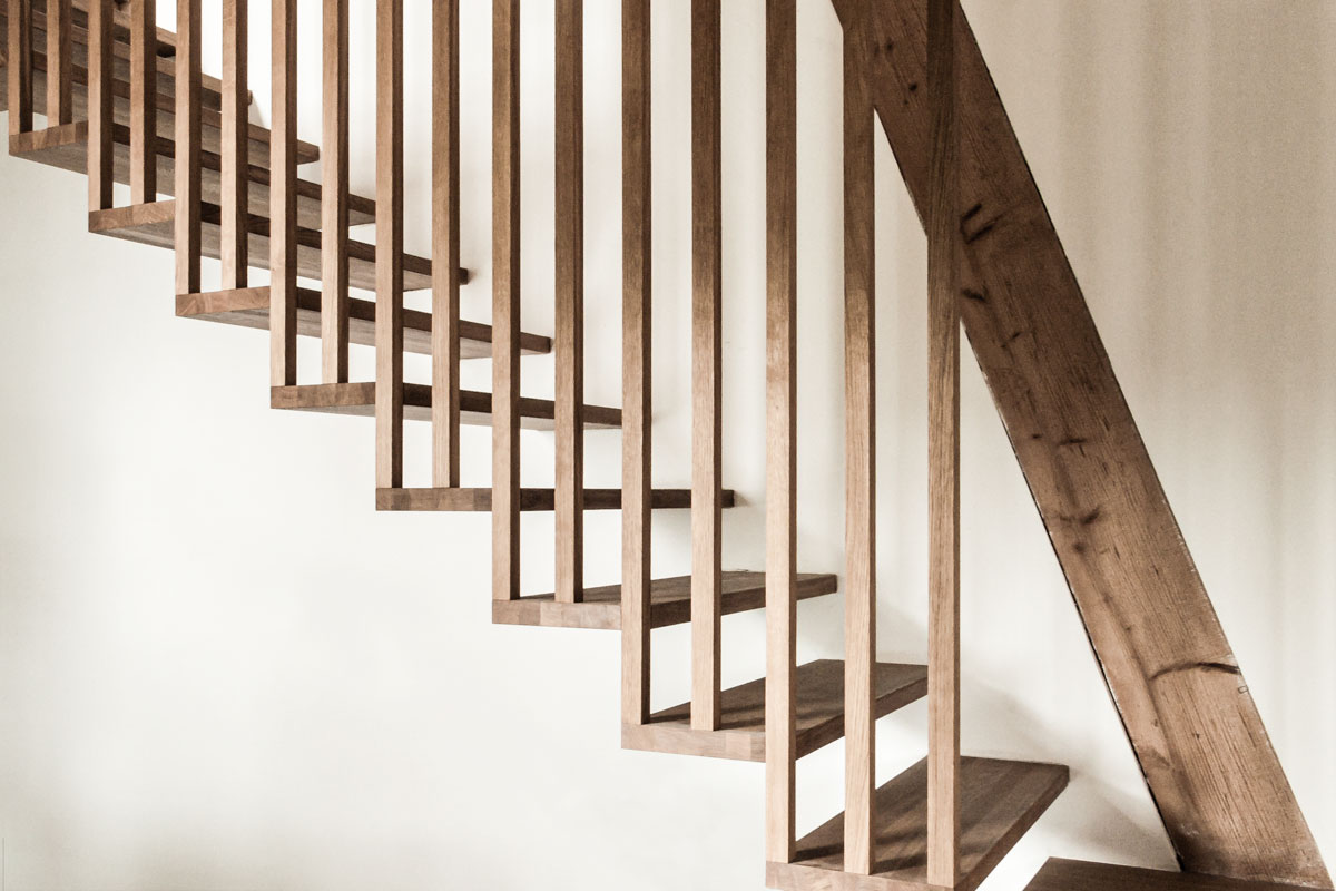 die-filigranen-staketen-aus-eichenholz-an-denen-die-treppe-aufgehaengt-ist-wurden-auf-das-konstruktive-minimum-reduziert
