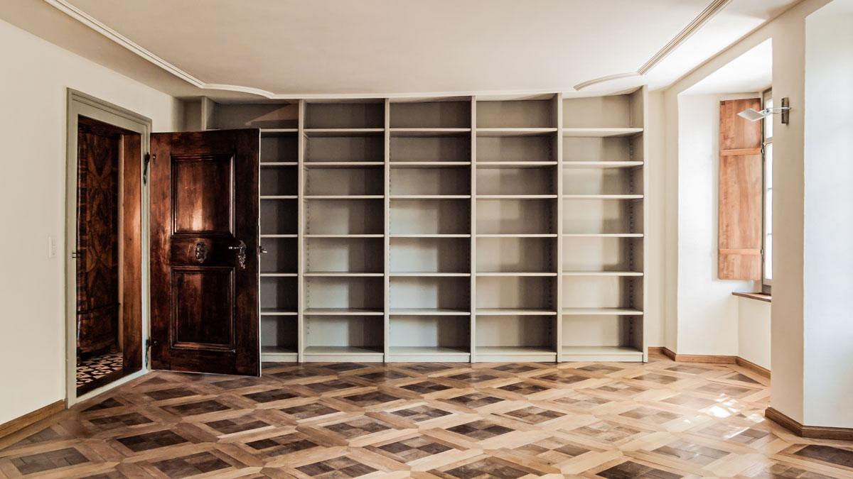die-blibliothek-hat-einen-schönen-historischen-tafel-parkett-eine-grau-gefasste-nussbaum-tuer-und-fenster-mit-innen-laeden