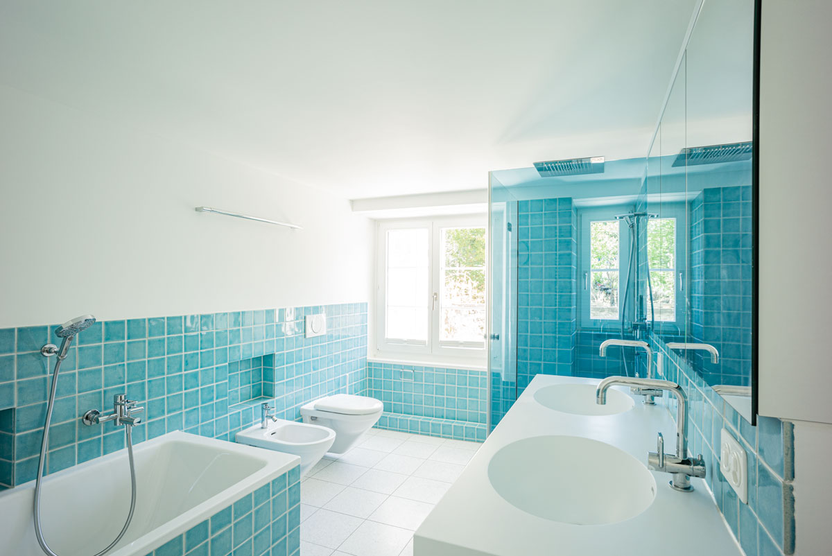 modern-umgebautes-badezimmer-mit-grossem-waschtisch-handgefertigten-hellblauen-kacheln-und-weissen-terrazzo-zementplatten