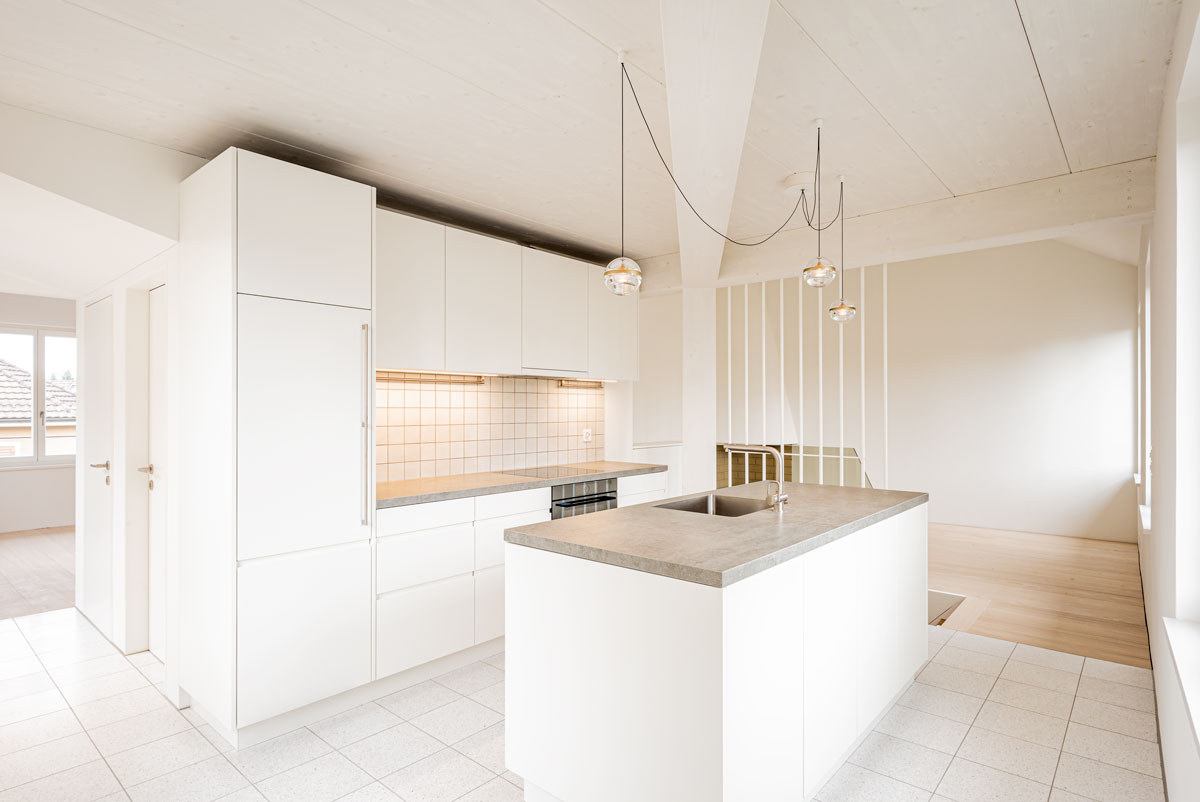 moderne-offene-minimalistische-weisse-kueche-mit-abdeckungen-beton-weissen-terrazzo-zementplatten-und-glaskugel-leuchte