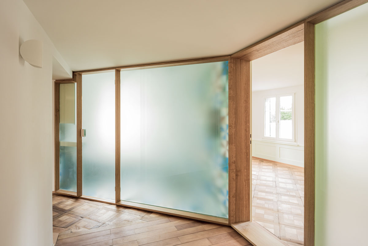 helles-entree-mit-historischen-parkettboeden-und-neuer-wand-zu-bad-und-zimmer-in-mattglas-mit-eichenrahmen