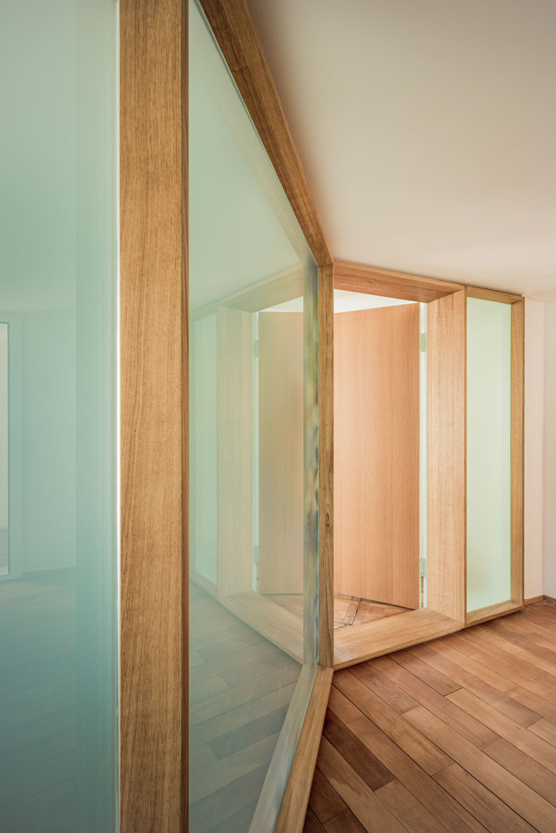 die-moderne-mattglas-wand-mit-eichenrahmen-und-integrierter-tuere-bringt-viel-licht-in-den-eingangsbereich