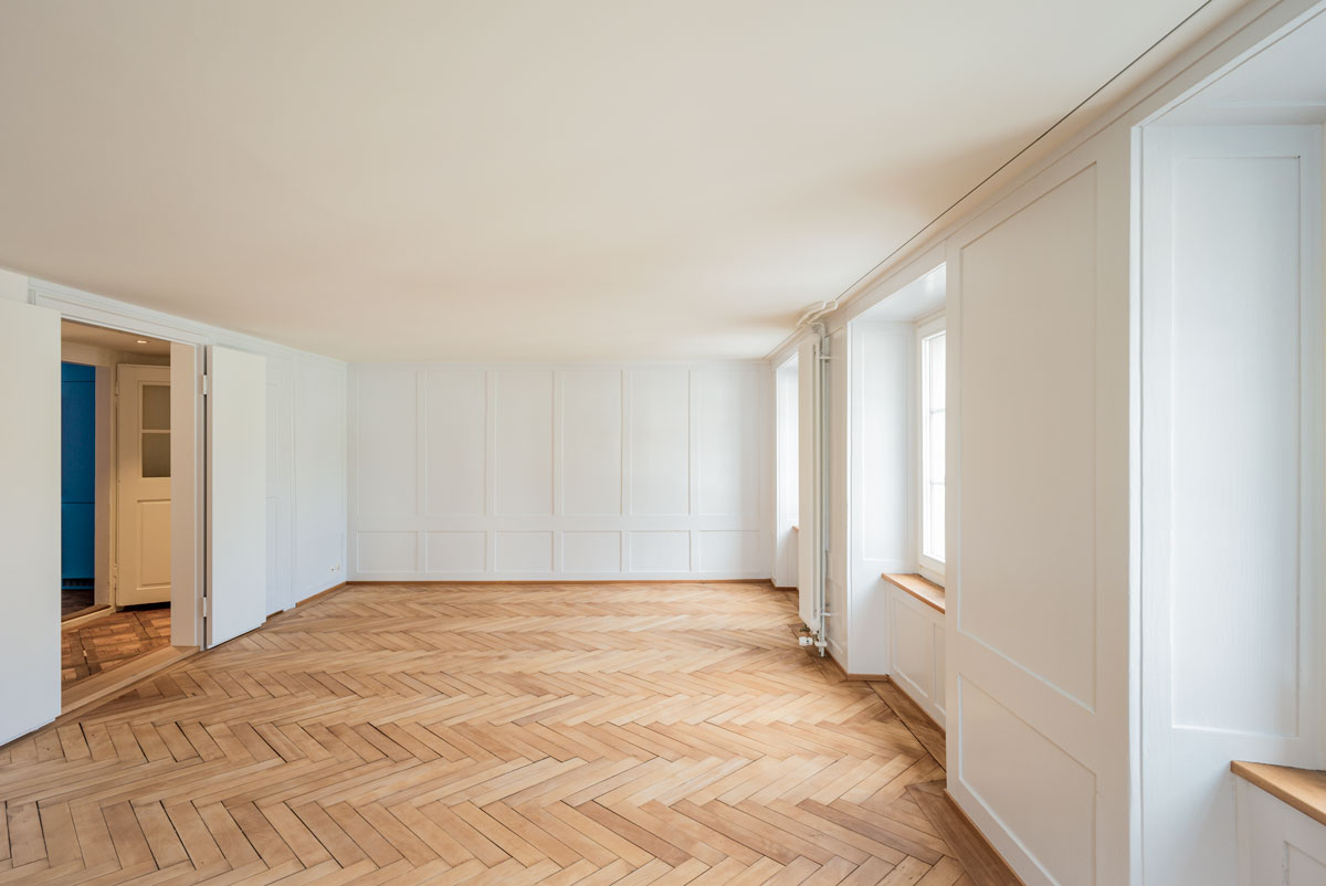 wohnzimmer-mit-historischem-hellblauem-taefer-fischgrat-parkett-in-eiche-und-neuer-doppelfluegel-tuer