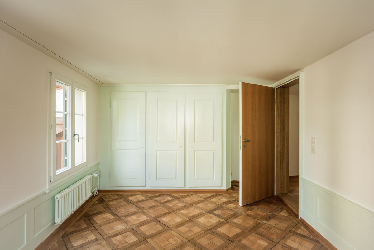zimmer-mit-hellgruenem-taefer-einbauschrank-und-tafelparkett-eiche-mit-moderner-tuer-und-eichenfurnier