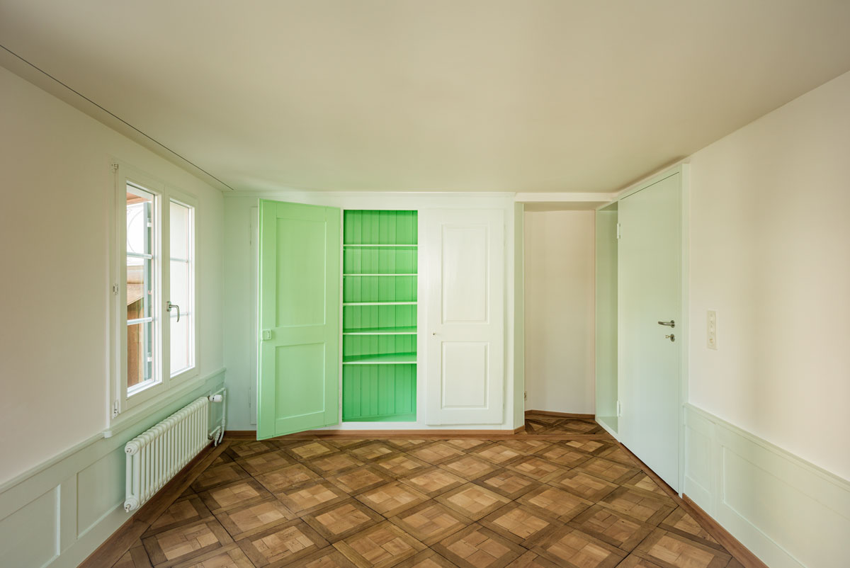 zimmer-mit-hellgruenem-taefer-einbauschrank-innen-gruen-und-tafelparkett-eiche-mit-moderner-tuer-hellgruen