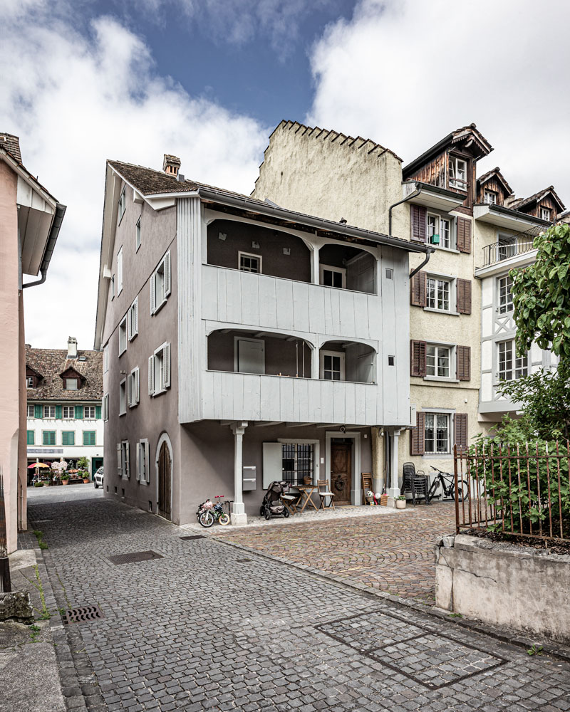 rueckansicht-des-altstadthauses-mit-eingang-zur-wohnung-und-doppelgeschossiger-historischer-laube-mit-holzverschalung