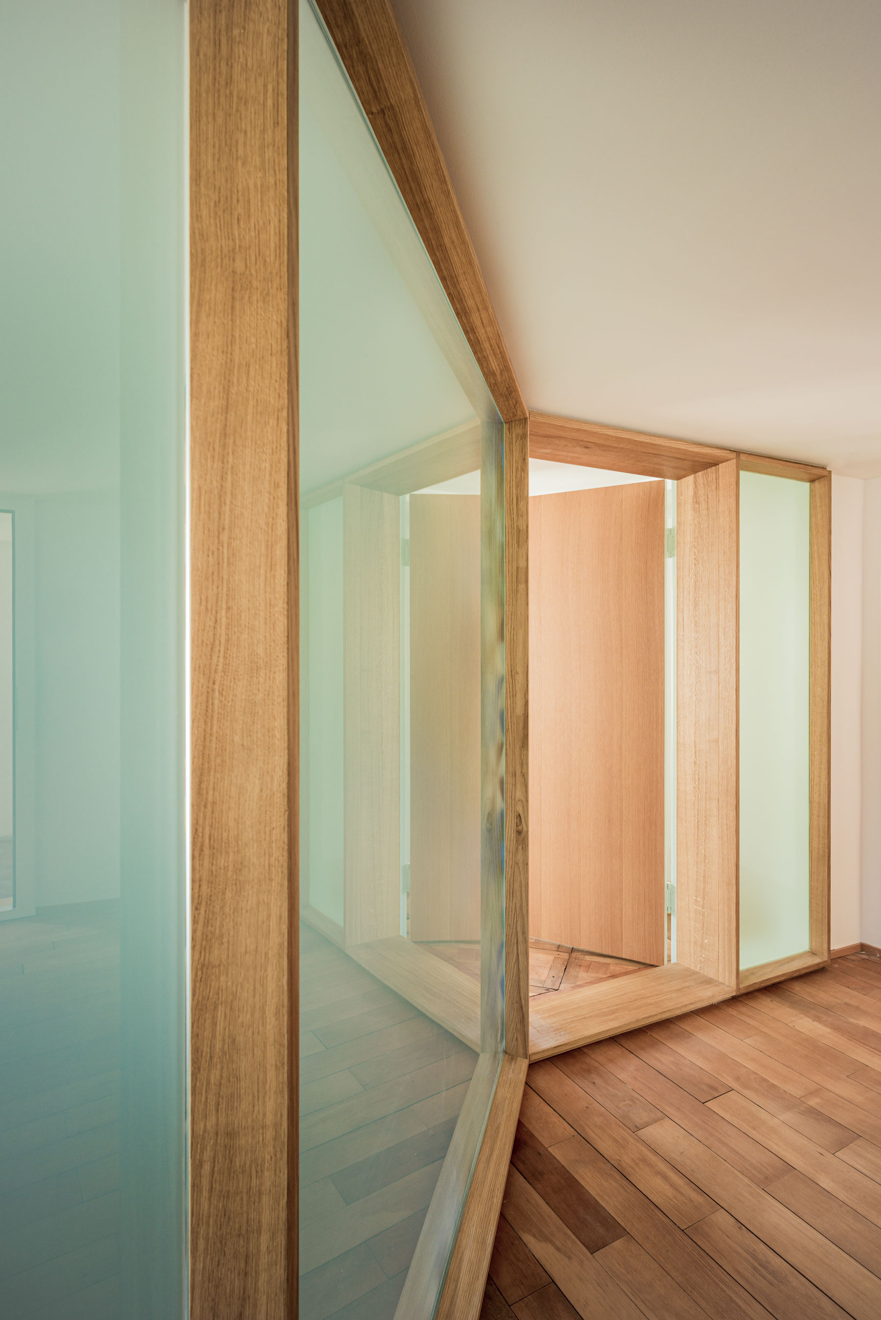 die-moderne-mattglas-wand-mit-eichenrahmen-und-integrierter-tuere-bringt-viel-licht-in-den-eingangsbereich